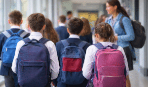 News 4 Uk School Children In Uniform Walking Through A School Hallway, Illustrating The Importance Of Keeping Children Safe In Education.